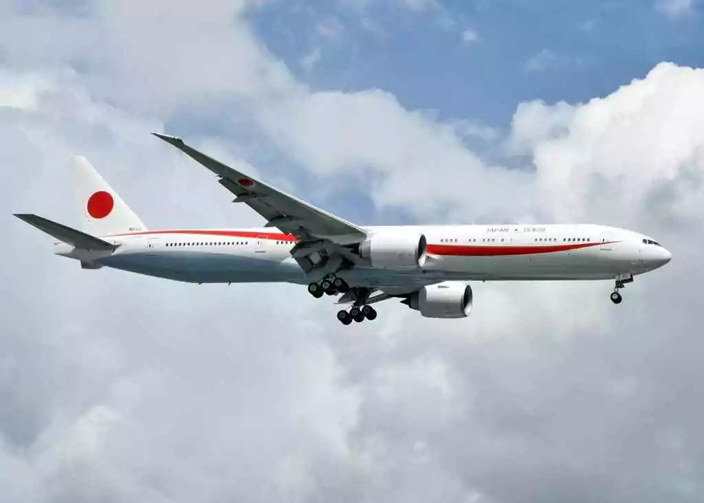 Japan Visa For UAE Residents: Unlock Your Dream Trip Now! 11 A Japanese Boeing 777 aircraft in mid-air against a backdrop of clouds, showcasing aviation elegance.