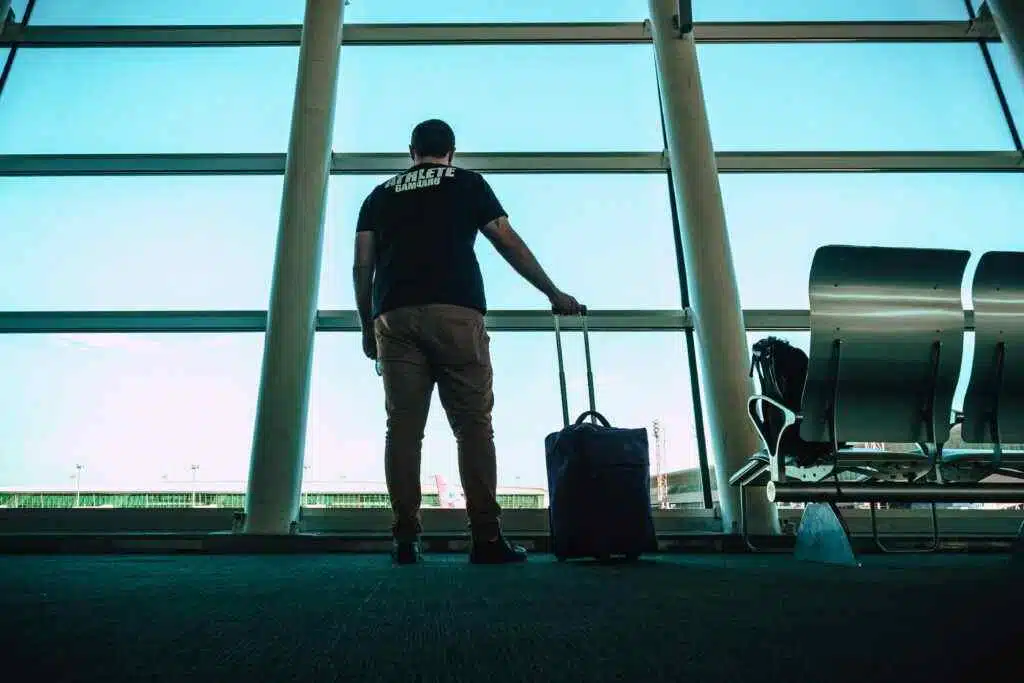Speed Up Your Travel: Sharjah Airport's Smart Gate Guide 5 Man with luggage waiting at airport lounge, anticipating departure in a modern setting.