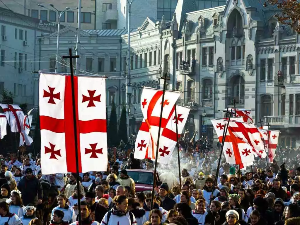 Your World Awaits: 15+ Visa-on-Arrival Countries for UAE 20 Crowd of people waving flags of Georgia during celebration of religious holiday on Christmas day in Tbilisi