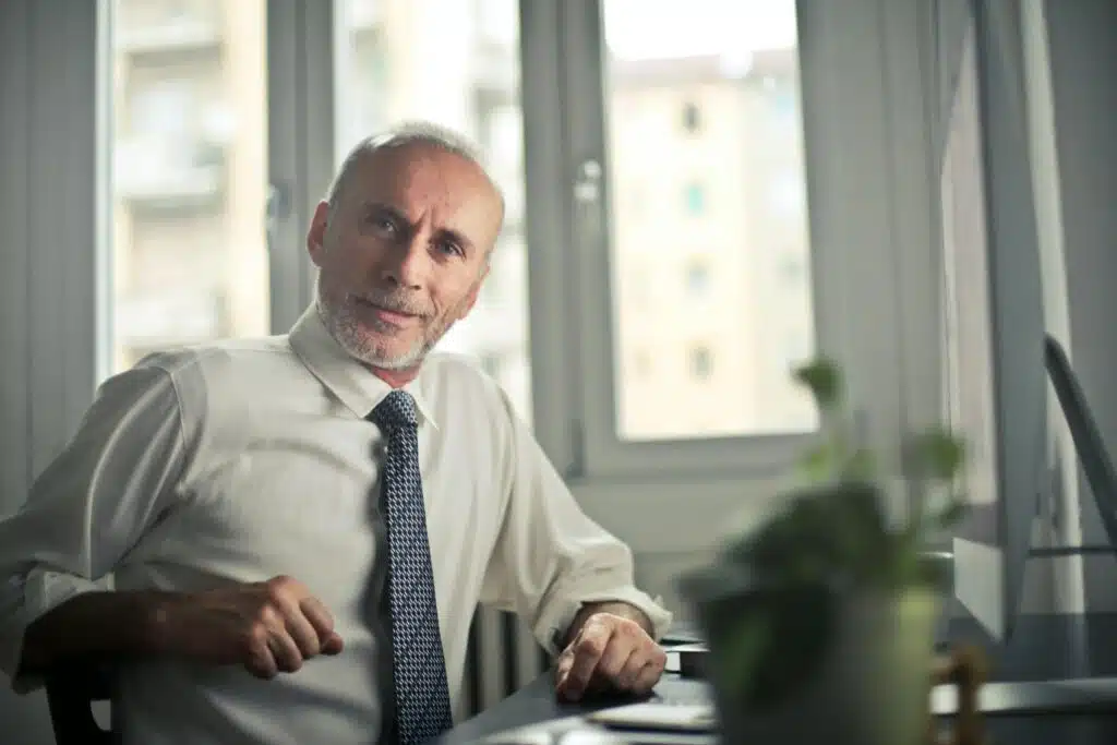 Your First Step to Success in Dubai: EGSH and the Road to Business Registration 2 A mature man in professional attire smiling in an office setting.