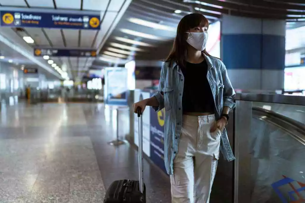 A woman holding her suitcase at the airport