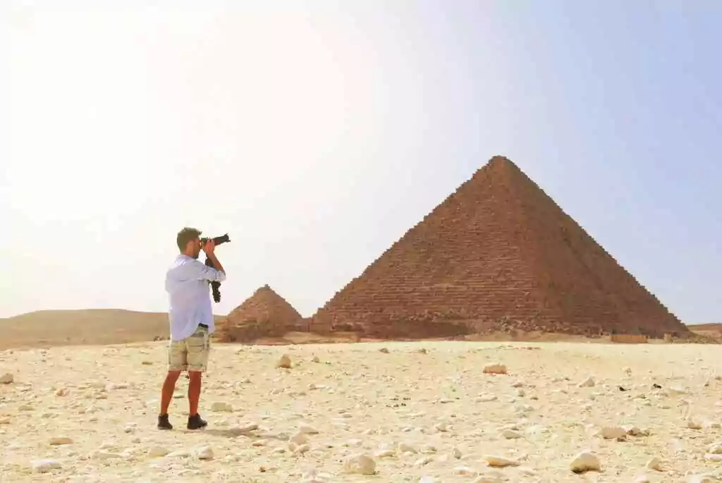 A man taking photo of a Egyptian pyramid