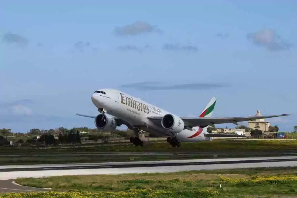 Emirates aircraft takes off against a clear blue sky, perfect for travel themes.
