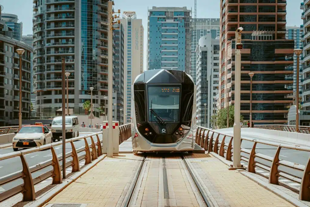 A sleek modern tram navigating through Dubai's urban architecture, showcasing innovative public transport.
