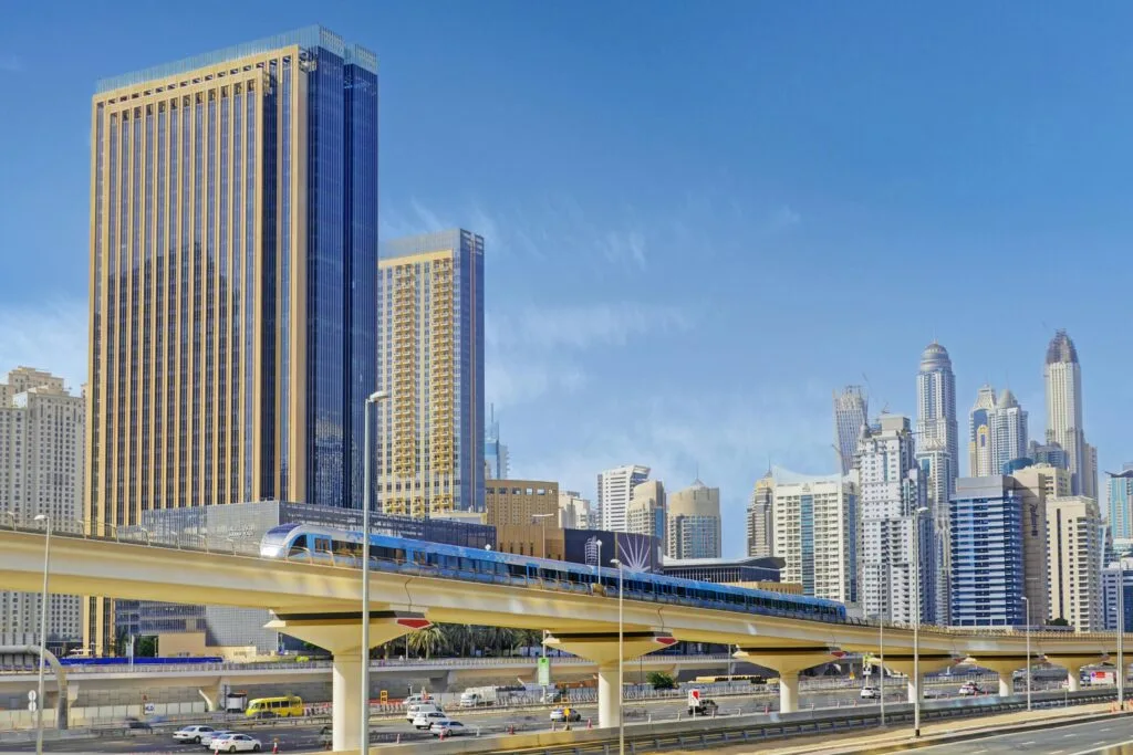 Stunning view of Dubai's iconic skyline with metro and high-rises under a clear blue sky.