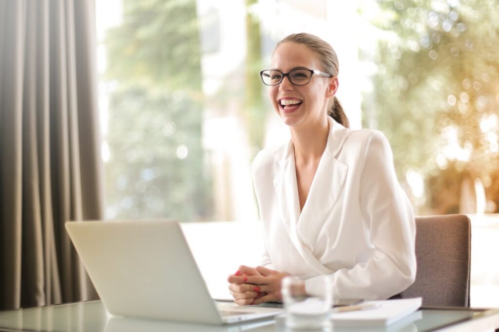 A woman smiling while using laptop