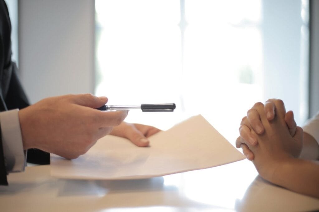 A man giving some documents to a woman