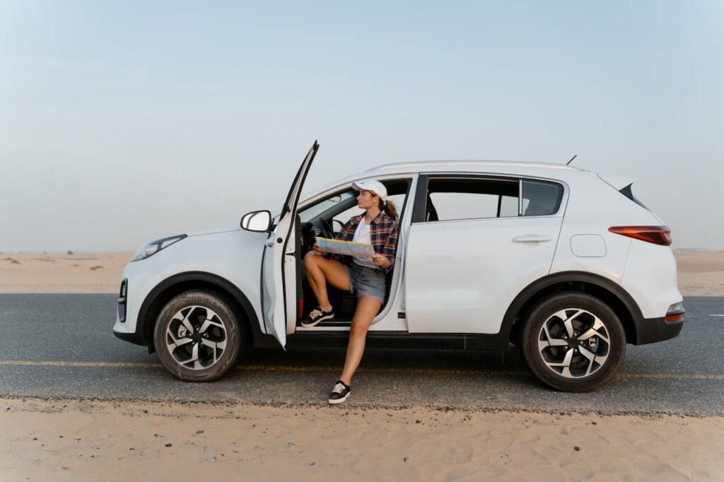 A girl sitting in a car while opening the front door