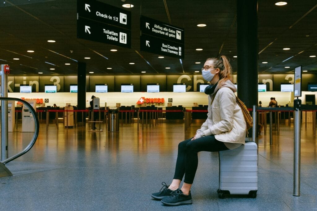 A girl at airport sitting on her bag