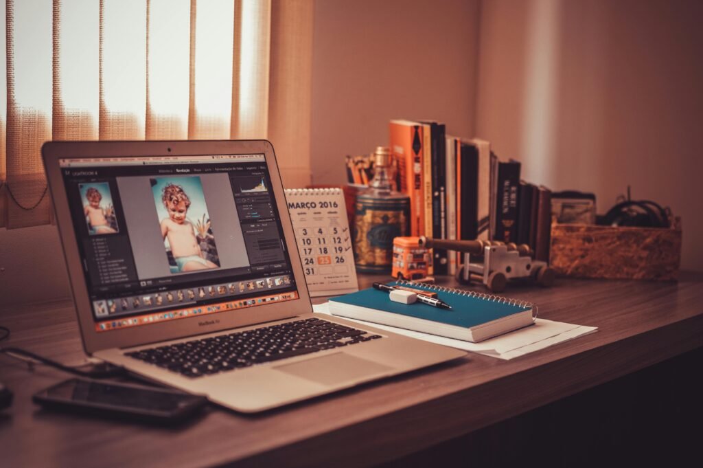 A laptop, a mobile, a book, a pen, a rubber, and a calendar on a table