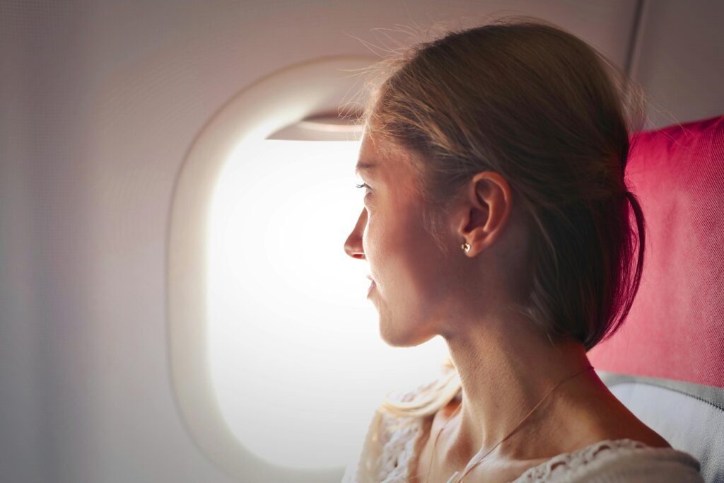 A girl looking toward the window of an airplane