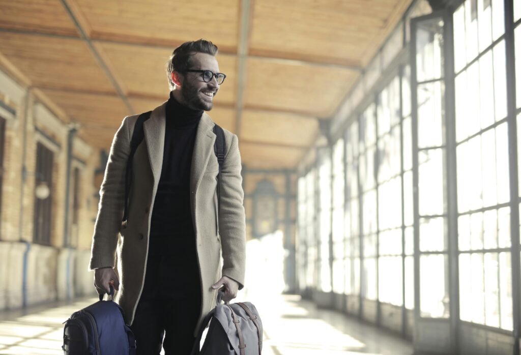 A smiling man having bags in hand