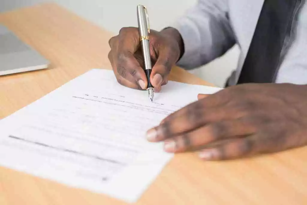 A man signing a paper.