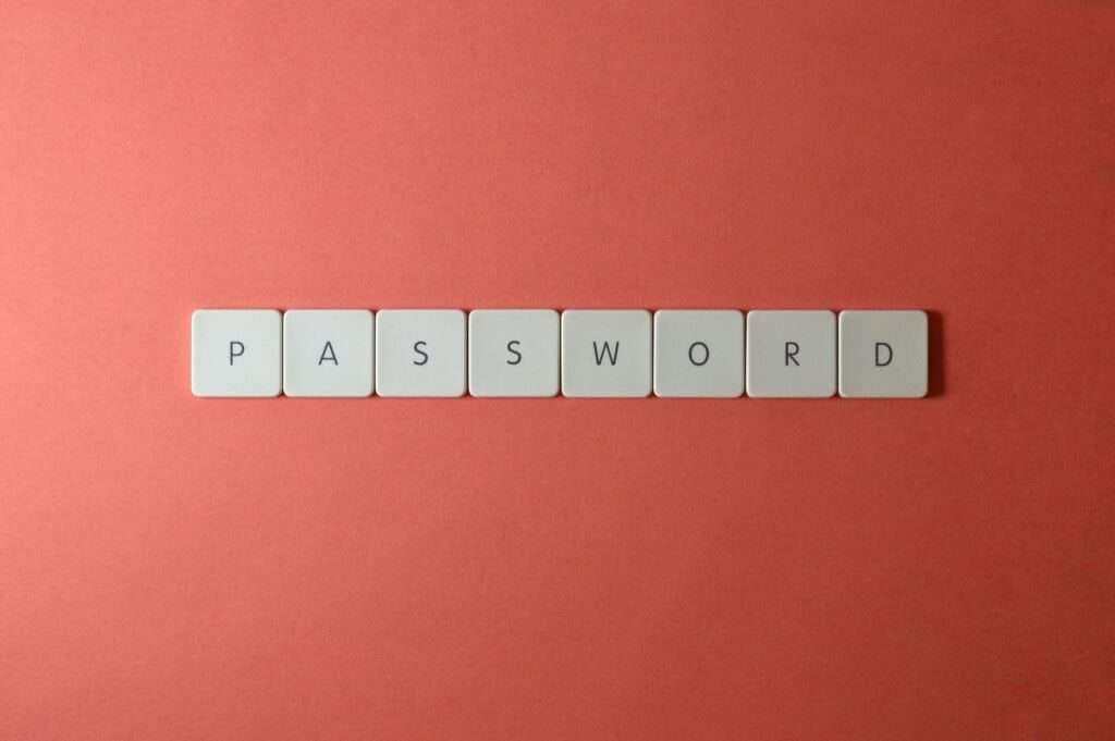 ركز على أمان كلمة المرور مع مربعات لوحة مفاتيح بيضاء مكتوب عليها ”PASSWORD“ على خلفية مرجانية.