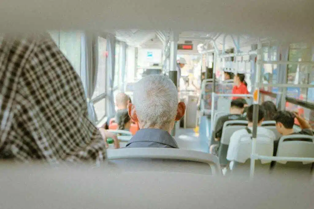 View of diverse passengers traveling in a city bus during the day.
