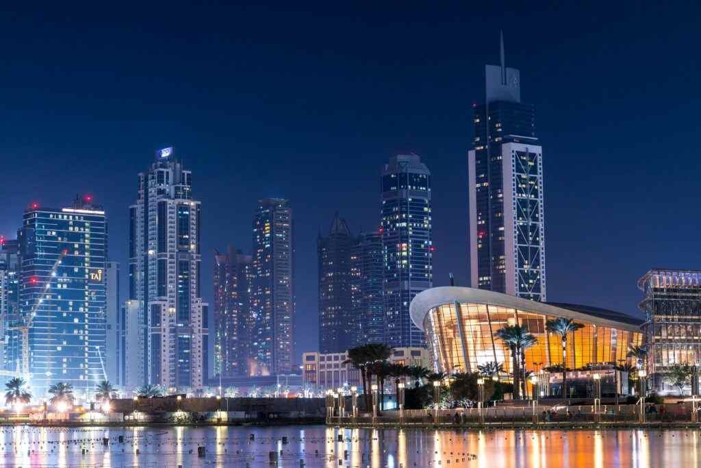 Dubai Azad Visa: Apply Now! 8 Stunning view of Dubai's illuminated skyline with modern skyscrapers reflecting on water at night.