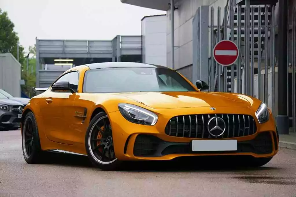 Gold luxury sports car parked on a UK street, showcasing sleek design and automotive elegance.