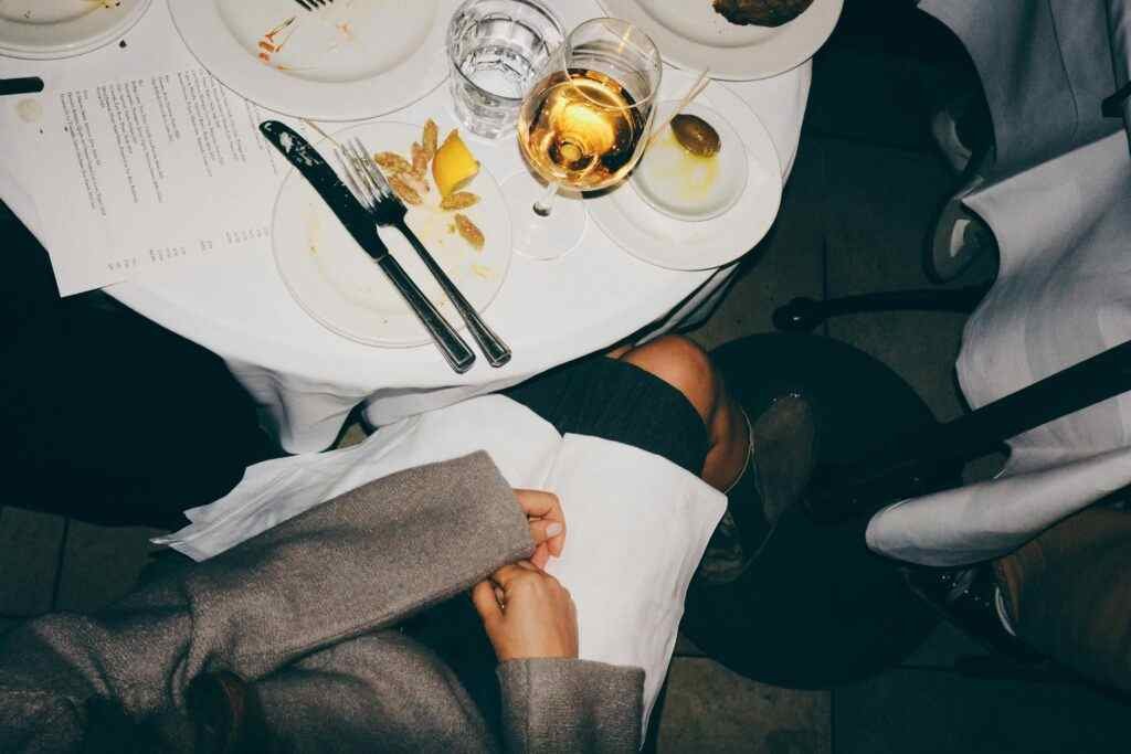 Where to Eat Cheap in Abu Dhabi? 5 Best Affordable Spots! 11 A top-down view of a dining table with elegant table setting and a glass of white wine.
