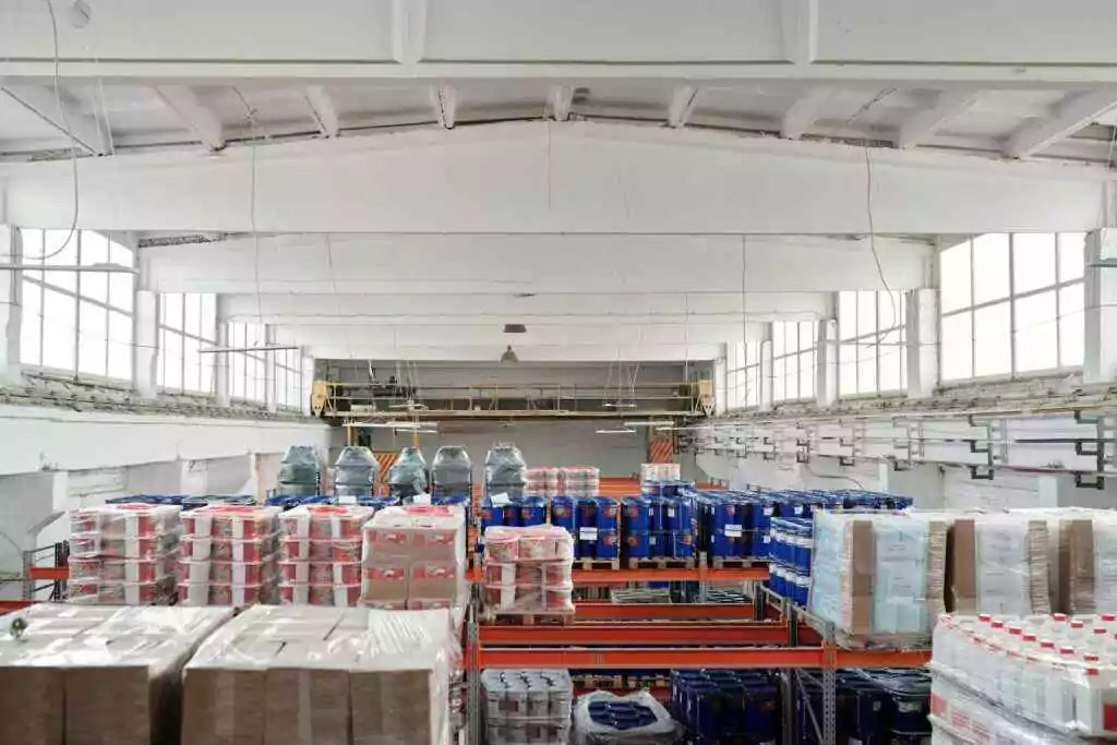 Dubai Trade Container Enquiry – Track & Locate in Seconds! 10 Spacious warehouse interior featuring organized shelves with various stacked pallets.