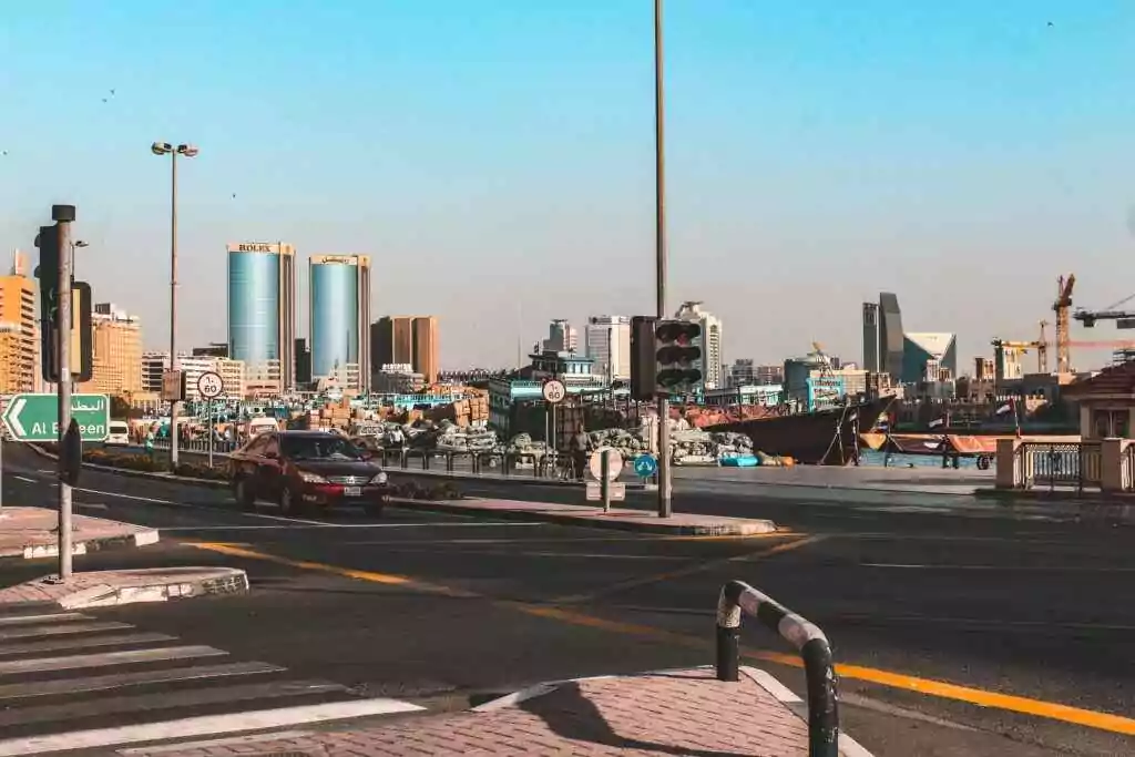 منظر حيوي لشارع نابض بالحياة في دبي يتميز بحركة المرور وأفق المدينة مع سماء صافية.