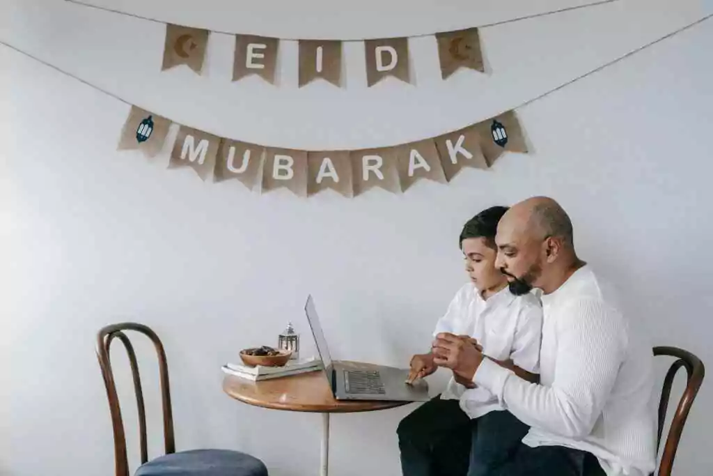 أب وابنه على مائدة مزينة لعيد الفطر المبارك، يترابطان ويتعلمان معاً.