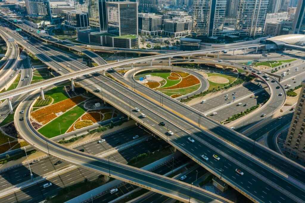 Aerial view of a bustling urban highway interchange amidst skyscrapers and modern architecture.