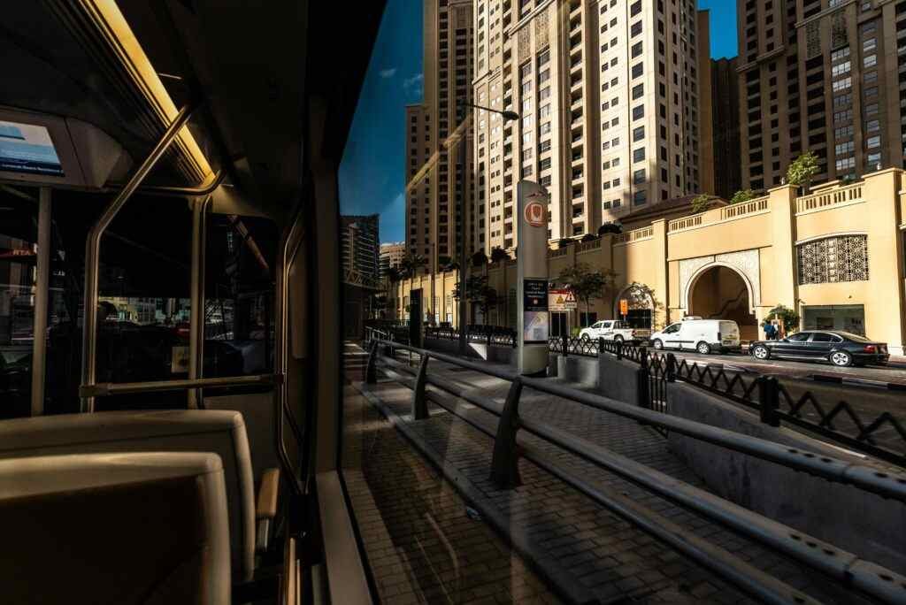 Dynamic urban scene captured from a tram, showcasing tall buildings lining the street in a bustling city.