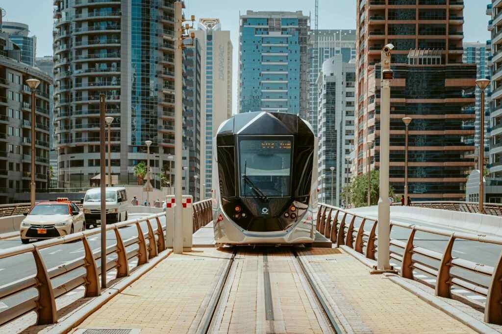 A sleek modern tram navigating through Dubai's urban architecture, showcasing innovative public transport.