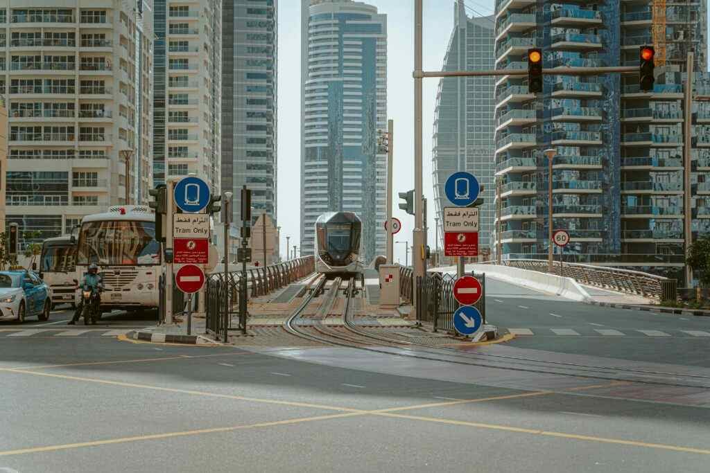 A sleek tram moves through the bustling cityscape of Dubai, showcasing modern urban transit.