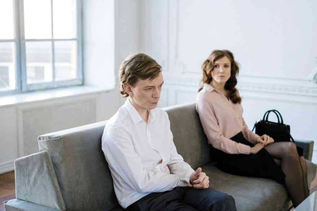 Signature Coaching Services A couple in a session with tense body language on a couch in a bright loft.