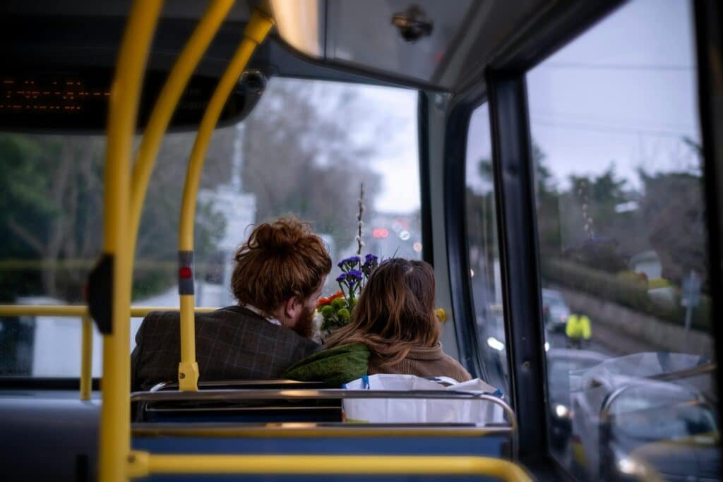 A romantic couple enjoys a scenic bus ride through the streets of Dublin, Ireland.