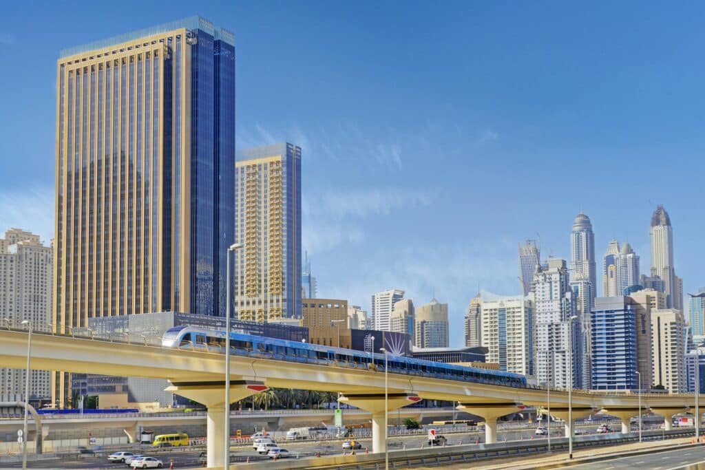 Stunning view of Dubai's iconic skyline with metro and high-rises under a clear blue sky.