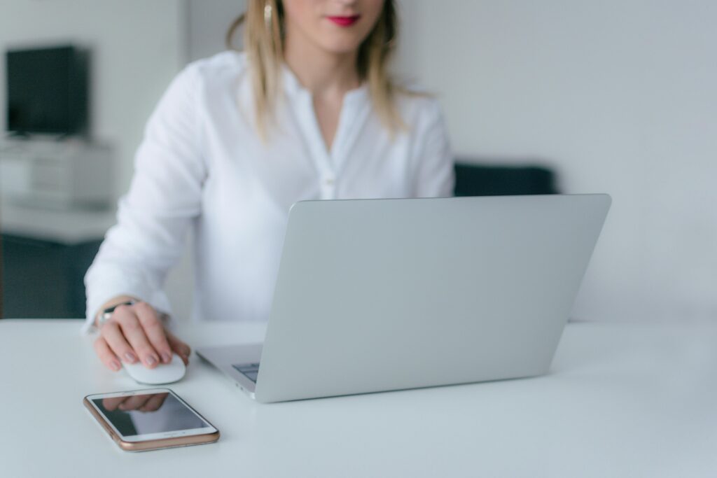 CPS Tester Online – Test & Boost Your Click Speed (1–60s) 1 A woman working at a desk using a laptop and smartphone, exemplifying remote work.