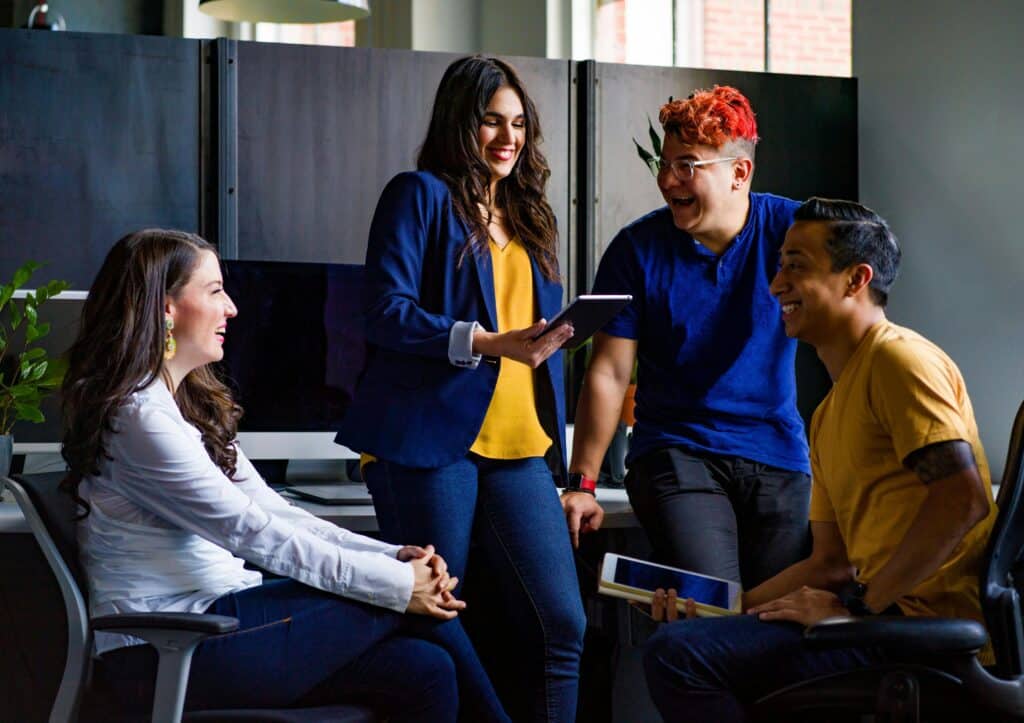 Innovation Meets Ambition: How Coworking Spaces in ADGM Empower Startups 2 A diverse group of coworkers engaging in a lively discussion in a stylish office environment.