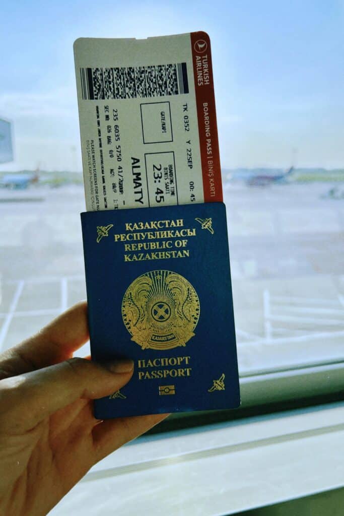 Kazakhstan passport with boarding pass in UAE airport, ready for travel.