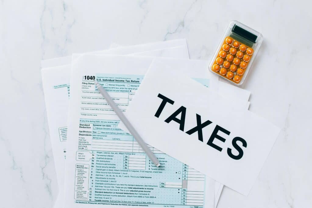 How to Calculate Tax in UAE 2026 4 Top view of tax forms, a calculator, and pen for tax preparation.