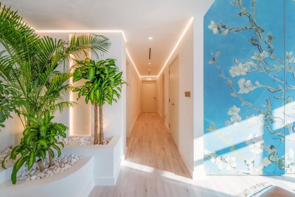 Elegant hallway by the best renovation company in Dubai featuring modern lighting, wood flooring, and artistic decor.