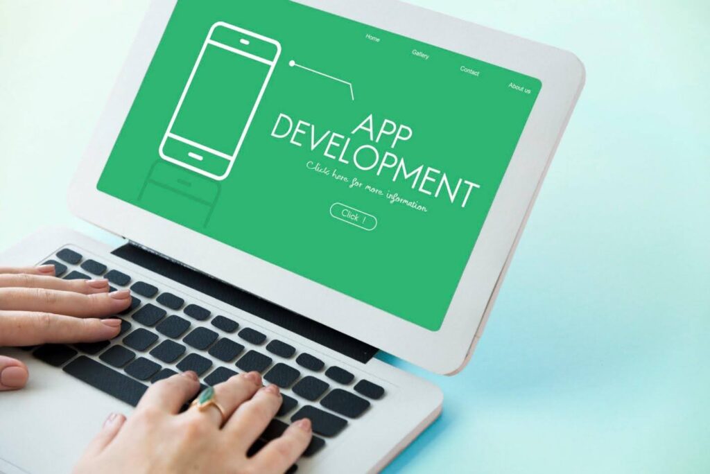A laptop with a poster on App Development on its screen