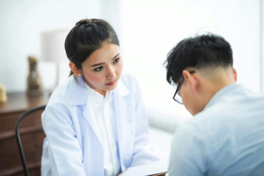 A doctor attentively listens to a patient during a medical consultation, emphasizing care and understanding.