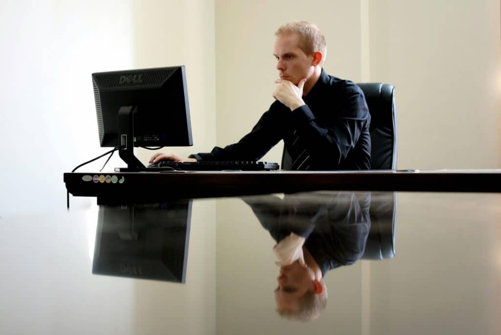 A businessman in deep thought at his desk, reflecting on work tasks.