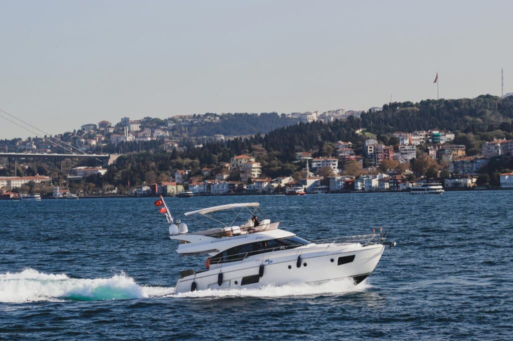 How to Rent a Yacht in Dubai: A Complete Beginner's Guide 2 Luxury yacht cruising along the Bosphorus with Istanbul's skyline in the background on a sunny day.