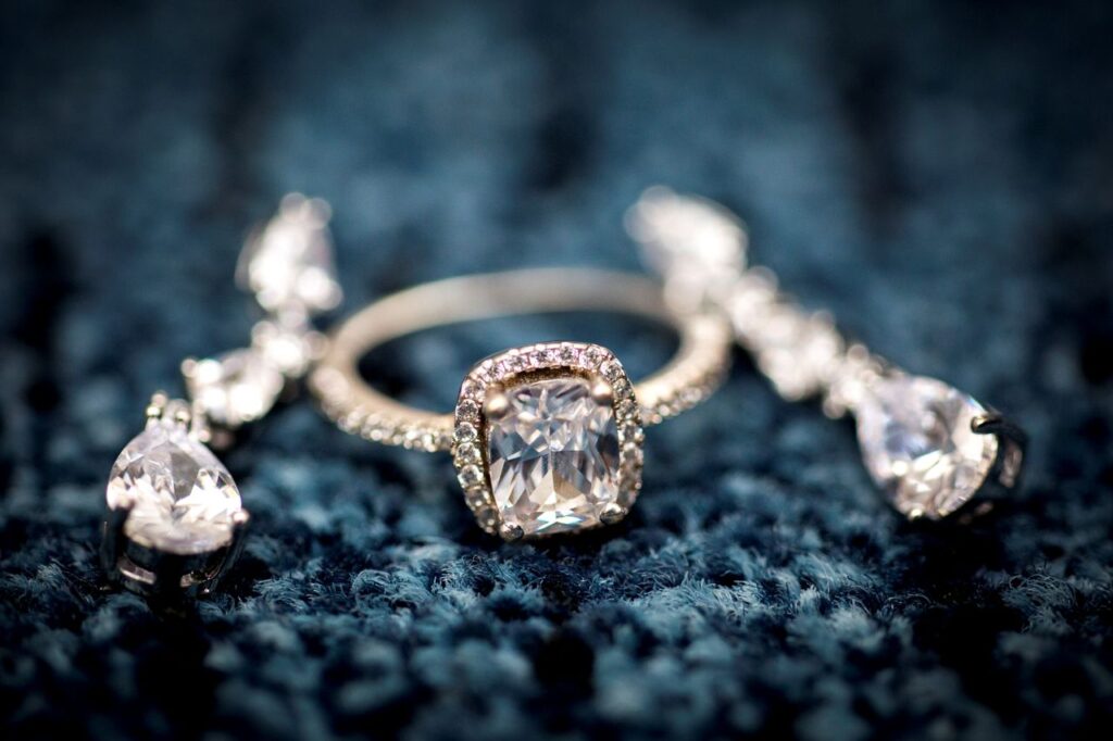 pexels-photo-36845933-36845933 Stunning diamond ring displayed on a textured blue background, showcasing elegance and craftsmanship.